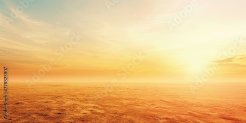 A large, empty field with a bright orange sun in the sky. The sky is mostly clear, with only a few clouds scattered throughout. The sun is positioned low in the sky photo