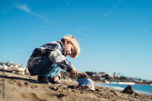 Toddler on vacation. Boy plays with a toy car on the seashore. boy 3-yers old playing on the seashore with a truck. carefree childhood. baby playing at sea
