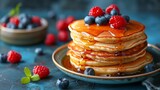 Stack of Pancakes Topped With Berries and Syrup