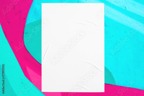 Closeup of colorful messy painted urban wall texture with wrinkled glued poster template. Modern mockup for design presentation. Creative pink mint green blue urban city background. 