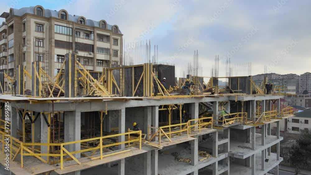 An aerial flight over a construction site. Construction workers are working at the site. An aerial flight over a construction site. Construction workers are working at the site.