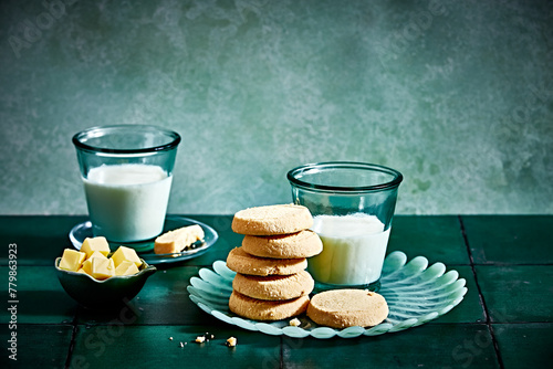 All butter shortbread biscuits with butter cubes and glasses of milk