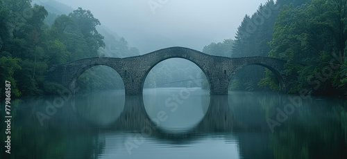 A photograph of an ancient stone bridge over a river, surrounded by a misty forest and reflecting in calm waters. Created with Ai