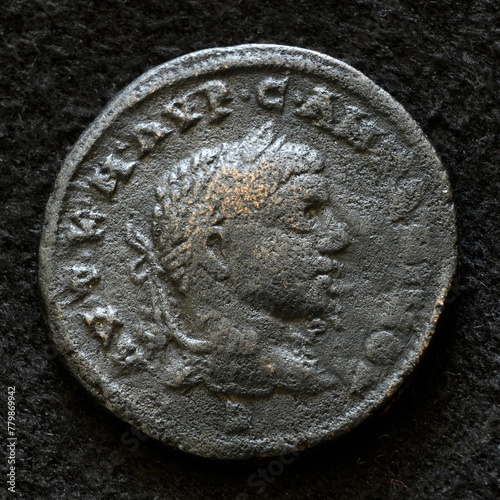 Ancient Roman coin of Emperor Elagabalus, top view of vintage metal money isolated on black background. Concept of old bronze texture, Rome, portrait, Empire, antique