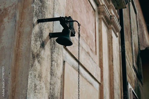 Obraz na plátně Antica campana in bronzo scuro montata sulla facciata storica di una chiesa o pa