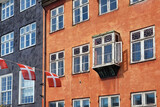 Danish flag and old windows on a colorful building in Copenhagen, Denmark