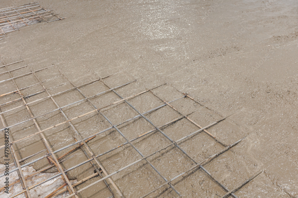 Closeup reinforced concrete structures, knitting of metal reinforcing cage. Iron frame for foundation floor, building site, top view