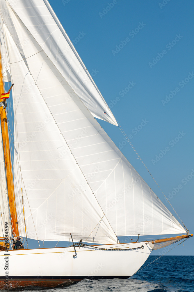Obraz premium White Dacron sails on a classic wooden sail boat with wooden masts.