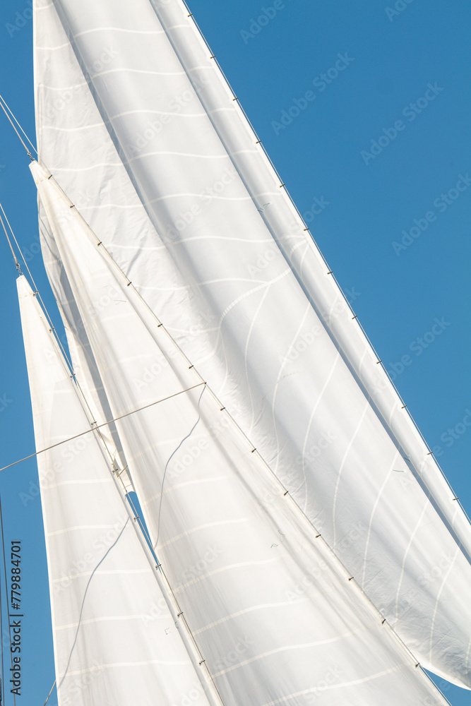 Fototapeta premium White Dacron sails on a classic wooden sail boat with wooden masts.
