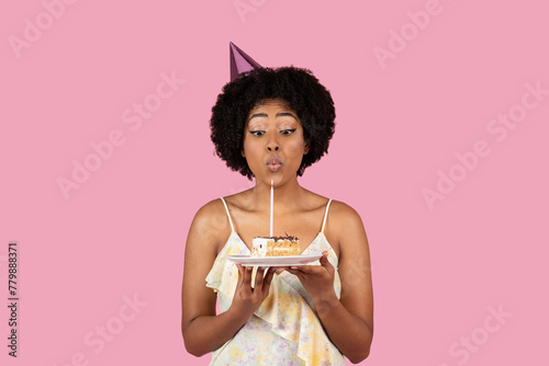 African American woman blowing out birthday candle