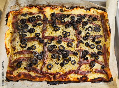 Baked pissaladière. Platter with this typical dish from the French Riviera. It consists of onion, black olives and anchovies on a dough. It is also known as French pizza