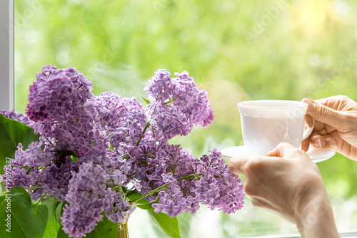 Home interior with a bouquet of blooming lilac flowers on the window. photo