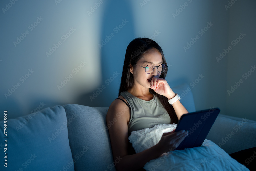 Woman with glasses and suffer from eye pain with use of digital tablet  in the evening at home