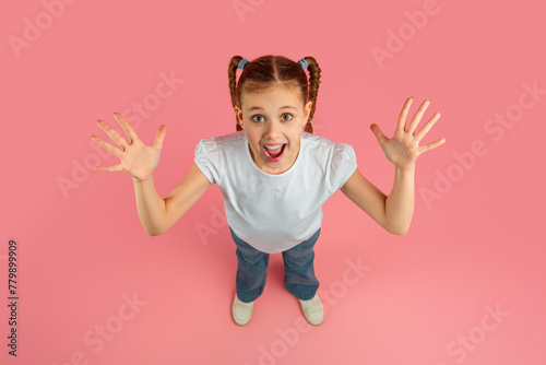Foto Excited girl with arms open on pink background