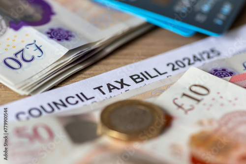 A close up of a United Kingdom local authorities Council Tax bill with bank notes, Pound coin and bank cards. photo