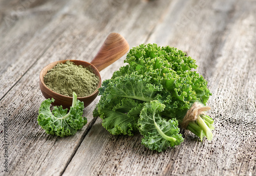 Kale leaves and powder on wooden background. Dehydrated food