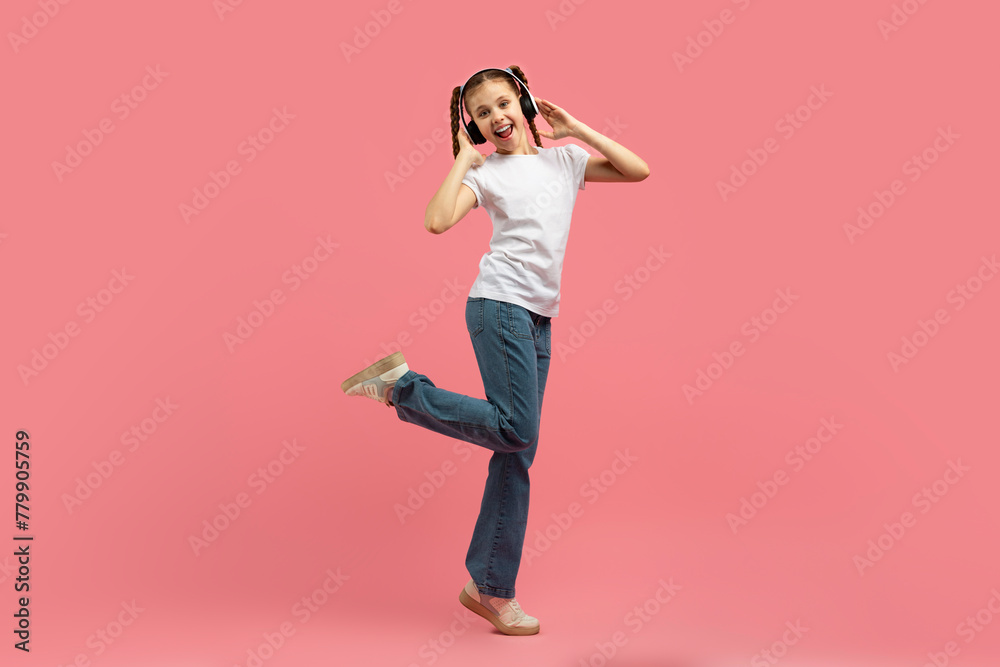 Girl in headphones dancing with one leg up