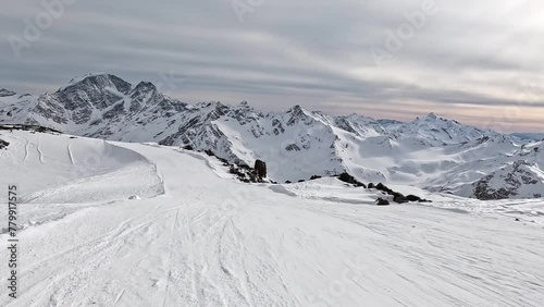 Skiing in mountains with stunning views of wild mountain range covered with fresh snow. Pov skier movement skiing down an empty slope at speed . Perfect winter outdoor activity sport. Slow motion, 4k