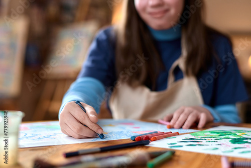 Close up of unrecognizable girl drawing pictures with crayons and enjoying art copy space
