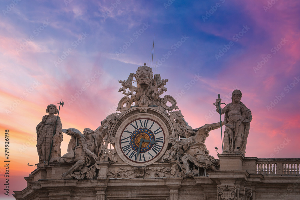Stunning view of ornate clock and sculptures against twilight sky at the Vatican. Features Roman numerals, religious statues, and crest with symbolic elements. Sunset or sunrise colors.