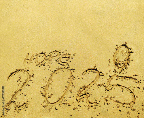 2025 number, word hope and happy face drawned on a beach sand. Abstract background photo to coming New Year 2025 photo