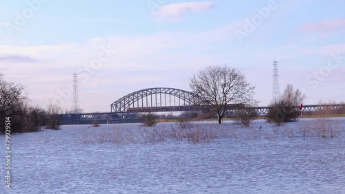Train rides over bridge over the flooded river Rhine in the Netherlands, in nature park Meinerswijk near Arnhem. photo