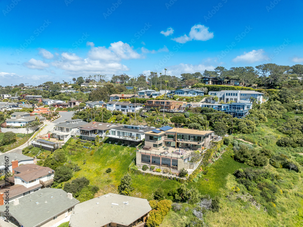 Aerial view of hillside luxury single family homes above Sunset Beach San Diego with palm trees and large terrace 