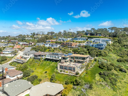 Aerial view of hillside luxury single family homes above Sunset Beach San Diego with palm trees and large terrace 