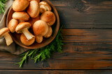 Fresh forest mushrooms /Boletus edulis (king bolete) / penny bun / cep / porcini / mushroom in an old bowl / plate and rosemary parsley herbs on the wooden dark brown table, top view background banner