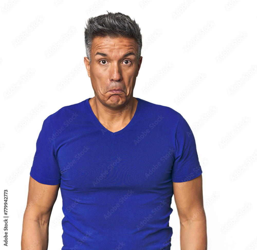 Fototapeta premium Middle-aged Latino man shrugs shoulders and open eyes confused.