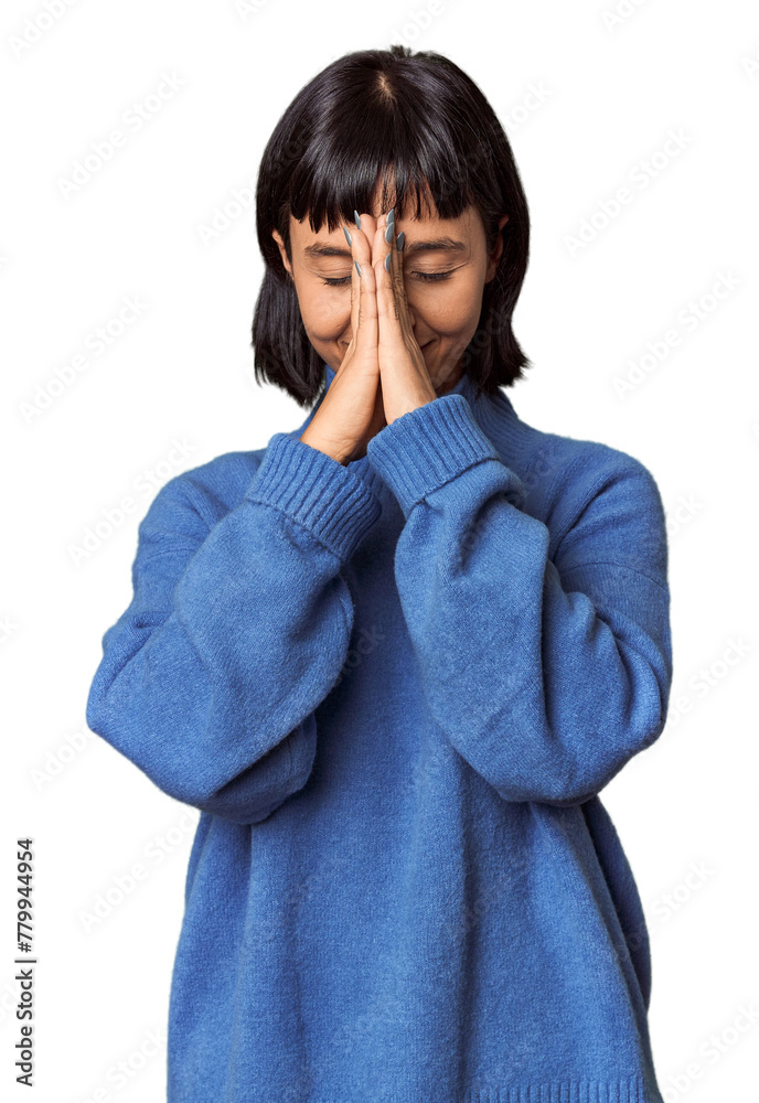 Young Hispanic woman with short black hair in studio holding hands in pray near mouth, feels confident. Young Hispanic woman with short black hair in studio holding hands in pray near mouth, feels confident.
