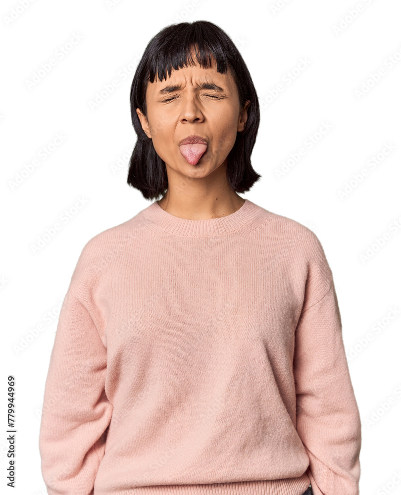 Young Hispanic woman with short black hair in studio funny and friendly sticking out tongue.