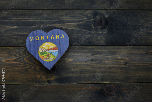 wooden heart with national flag of montana state on the wooden background.