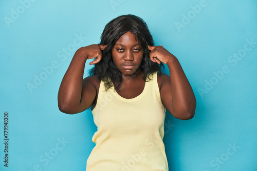 Young african american curvy woman focused on a task, keeping forefingers pointing head. photo