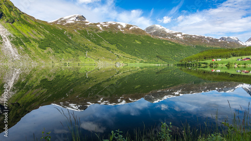 schneebedeckte Berge spiegeln sich im See Eidsvatnet in Norwegen