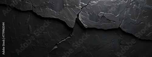 A smooth, matte black background with a single, deep crack running across it