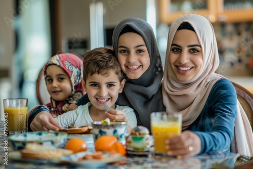 Family Joy at Breakfast Time. A smiling Arab mother with her children enjoying breakfast.