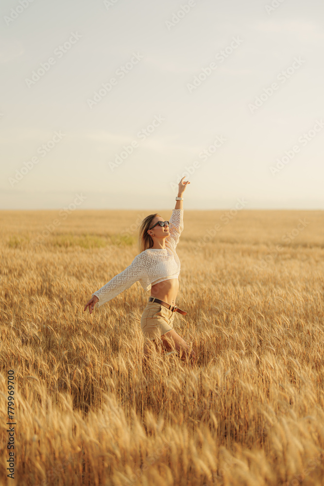 A joyful young woman with arms raised in a vast, golden wheat field under the open sky, conveying a sense of freedom, summer, and happiness. A joyful young woman with arms raised in a vast, golden wheat field under the open sky, conveying a sense of freedom, summer, and happiness.