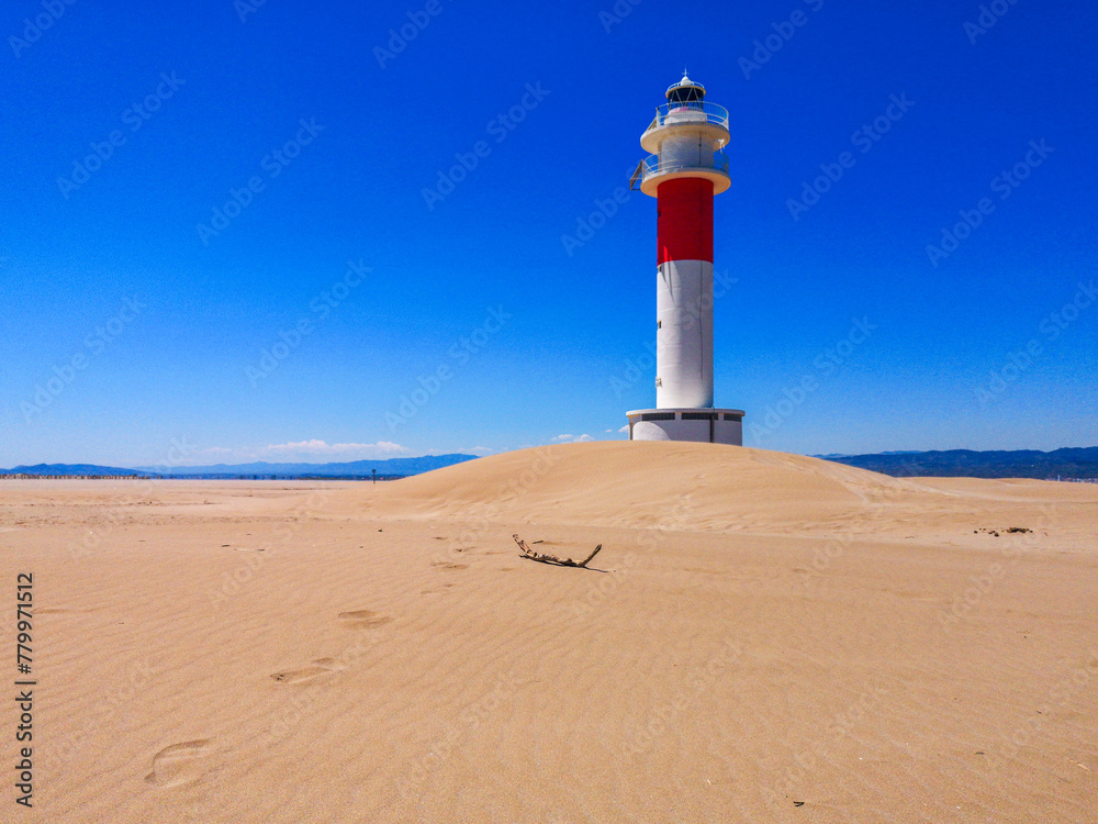 Horizontal. Lighthouse on the sand in the Ebro Delta with a blue sky in the background.