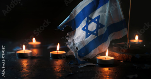 Candlelight and Flag of Israel. Lit candles with an Israeli flag in the background, dark ambiance. World Holocaust Day. Yom azikaron in Hebrew Memorial Day. Day of Remembrance