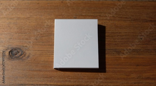 A blank white card resting on a wooden table.
