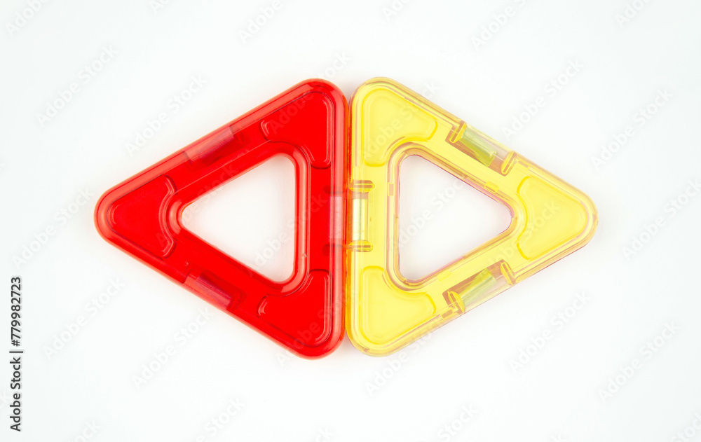 Two plastic triangles from transparent magnet constructor kit (puzzle builder for kids) isolated on a white background Two plastic triangles from transparent magnet constructor kit (puzzle builder for kids) isolated on a white background