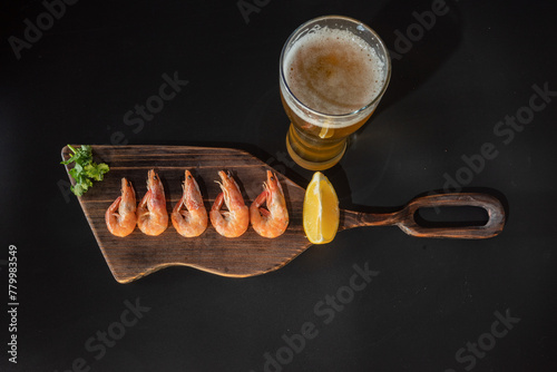 Boiled shrimp and a glass of beer. Shrimp and lemon. Lager beer and snacks.