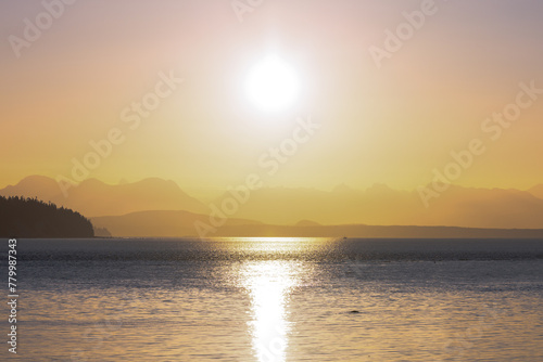 Golden Sunrise above the horizon with mountains and ocean