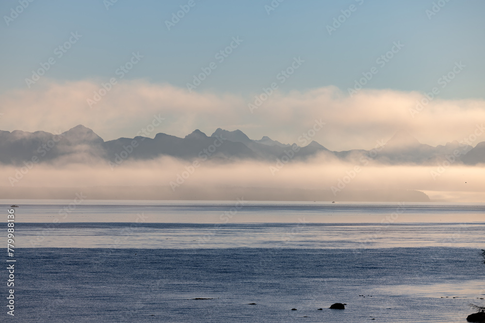 Obraz premium Misty lake framed by mountains, creating a serene natural landscape