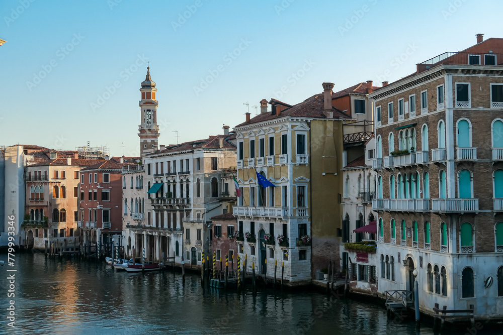 Scenic sunset view of Grand Canal (Grand Canale) in Venice, Veneto, Italy, Europe. Residential house area along the biggest water channel. Golden hour on the facades. Urban summer tourism