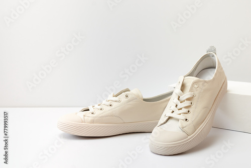 Pair of stylish sneakers on white background with geometric podium