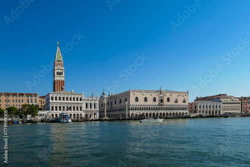 Scenic view of the channel Canala Grande tower of St Mark's Campanile in city of Venice, Veneto, Northern Italy, Europe. Venetian architectural landmarks. Romantic vacation. Speed boat passing by photo