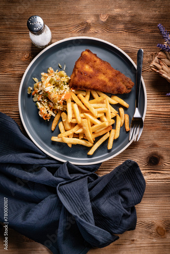 Fried cod fillet with fries and salad.