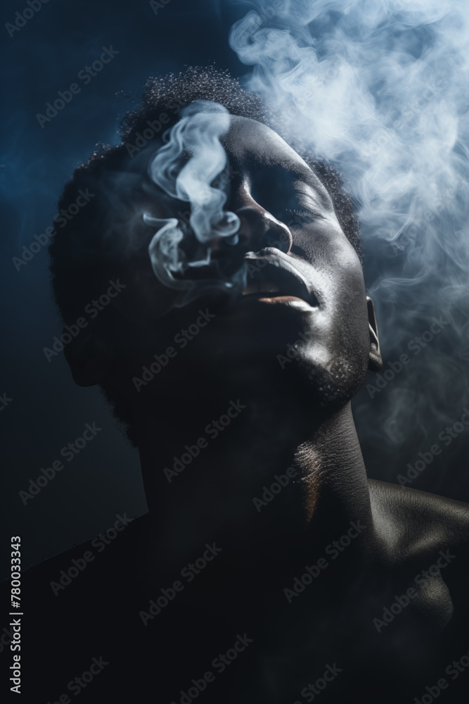 Portrait of a black man fading and dissolving into the smoke dark background. Closed eyes. Praying and supernatural mood. Ghostly. Also related to anguish, depression, withdrawal, lament, separation